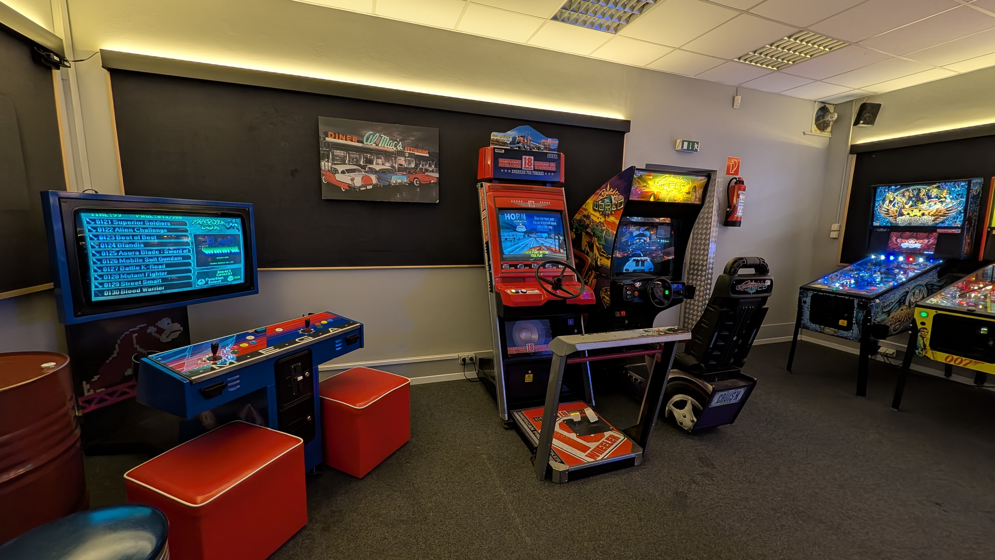 Spielhalle mit bunten Arcade Automaten Flippern und roten Sitzhockern